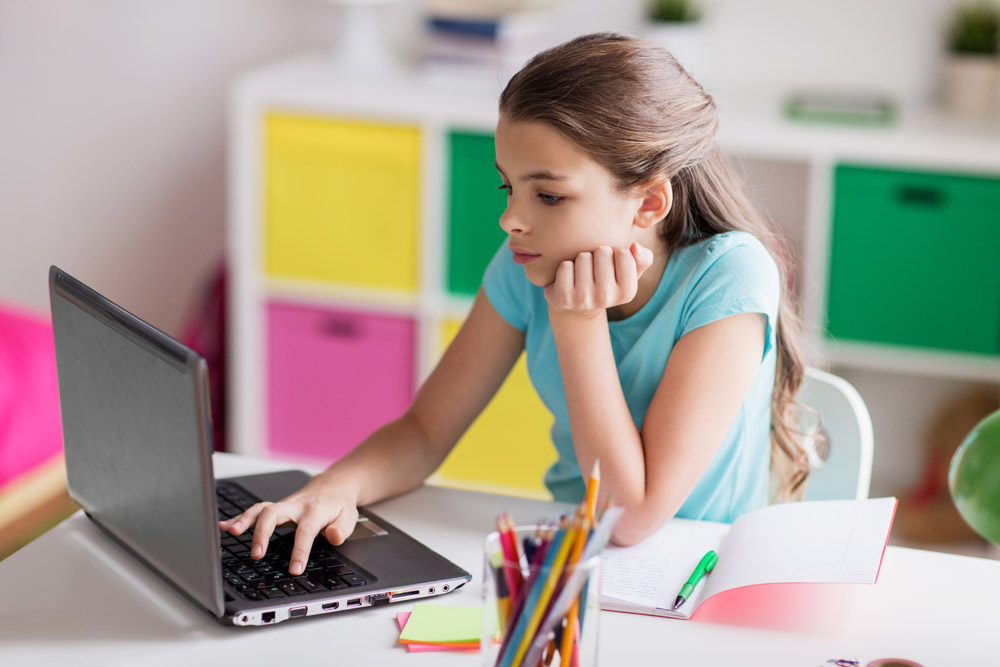 bored girl with laptop and notebook at home